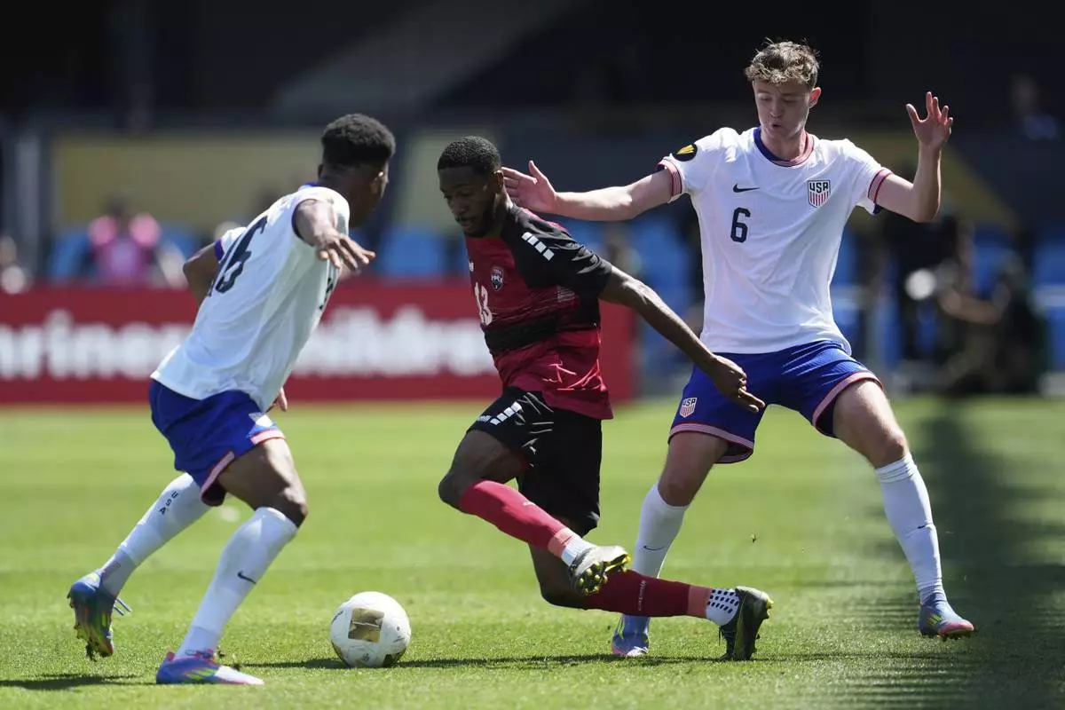 Trinidad and Tobago midfielder Tyrese Spicer, center, brings the ball upfield between United States defender Alexander Freeman, left, and midfielder Jack McGlynn (6) during the first half of a CONCACAF Gold Cup soccer match in San Jose, Calif., Sunday, June 15, 2025. (AP Photo/Jeff Chiu)