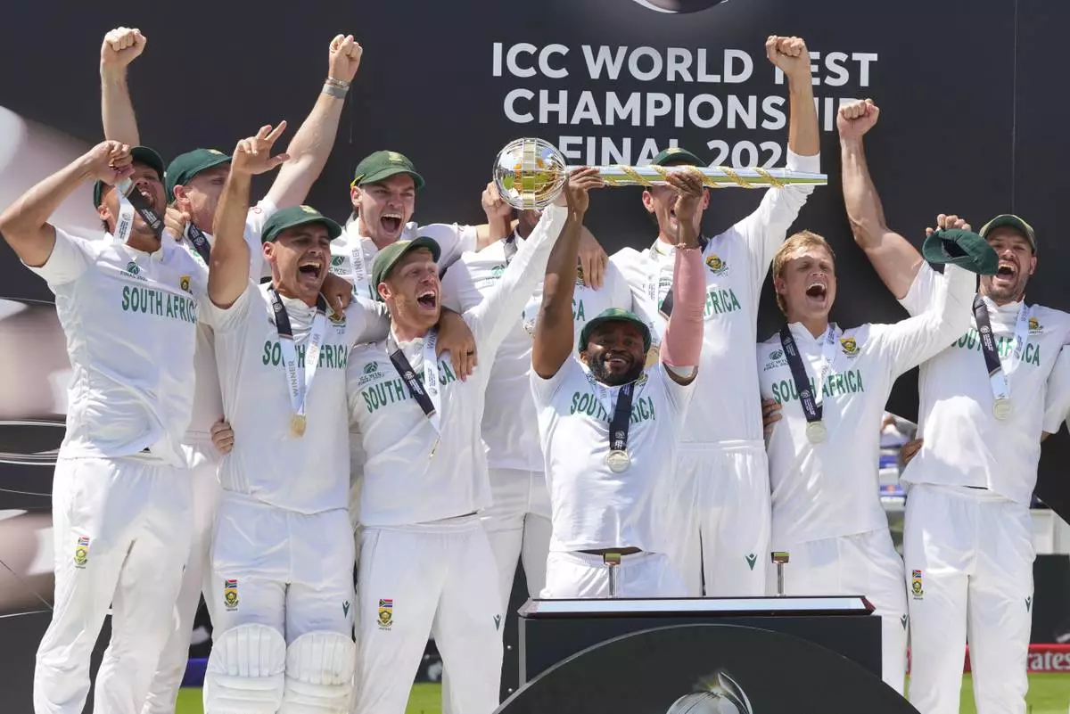 South Africa's captain Temba Bavuma holds the winner's trophy and celebrates with teammates on the podium after their win in the World Test Championship final against Australia at Lord's cricket ground in London, Saturday, June 14, 2025. (AP Photo/Kirsty Wigglesworth)