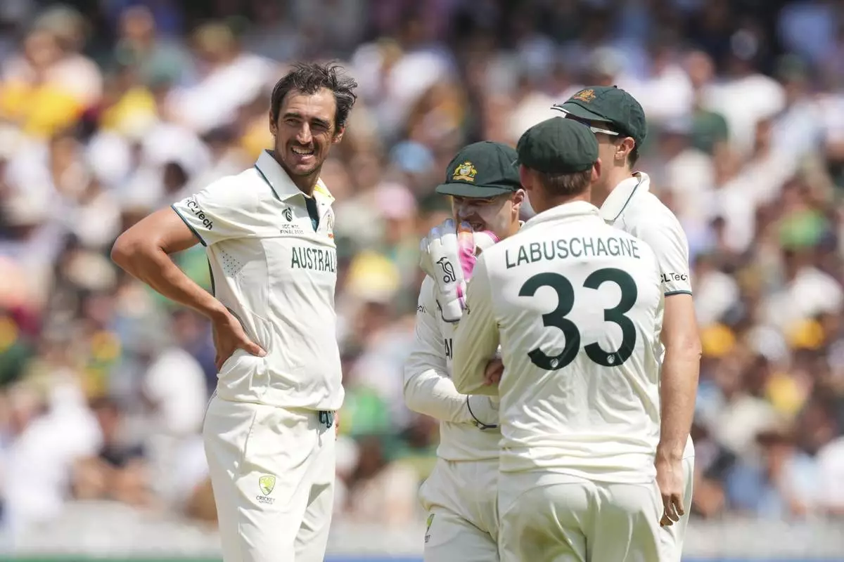 Australia's Mitchell Starc, left, chats with teammates before asking for a review for the wicket of South Africa's David Bedingham on day four of the World Test Championship final between South Africa and Australia at Lord's cricket ground in London, Saturday, June 14, 2025. (AP Photo/Kirsty Wigglesworth)