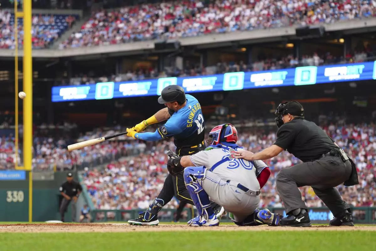 Philadelphia Phillies' Kyle Schwarber (12) hits a three-run home run off Toronto Blue Jays pitcher Kevin Gausman during the second inning of a baseball game, Friday, June 13, 2025, in Philadelphia. (AP Photo/Derik Hamilton)
