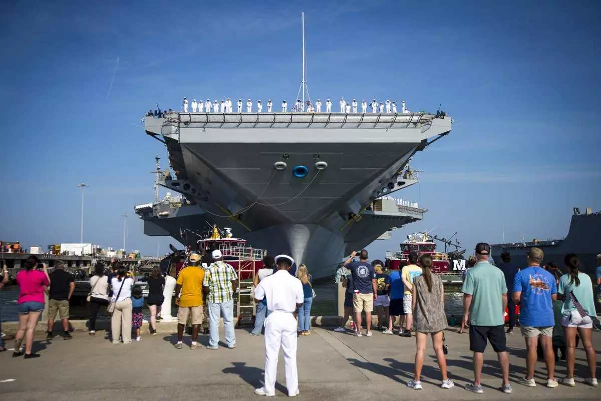 Family and sailors wave as the USS Gerald R. Ford aircraft carrier leaves Naval Station Tuesday, June 24, 2025, in Norfolk, Va. (AP Photo/John Clark)
