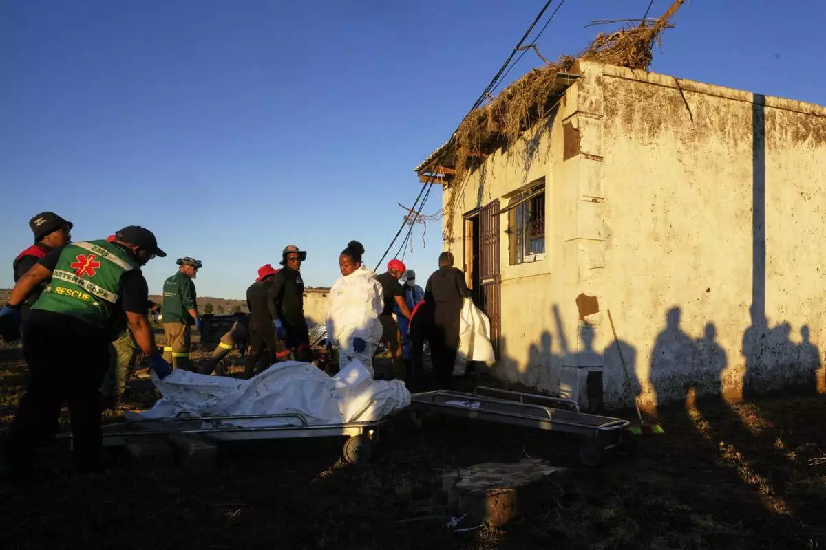 Forensic workers retrieve bodies of a mother and three daughters from inside a one room house after floods swept through the area in Mthatha, South Africa, Thursday, June 12, 2025. (AP Photo/Themba Hadebe)