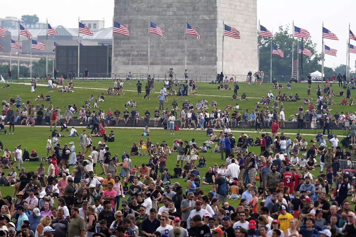 People on the lawn around the Washington Monument as President Donald Trump attends a military parade commemorating the Army's 250th anniversary, coinciding with his 79th birthday, Saturday, June 14, 2025, in Washington. (AP Photo/Julia Demaree Nikhinson)