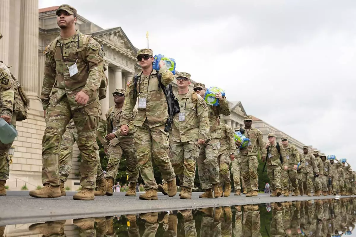 U.S. Army soldiers walking along Constitution Ave., on the National Mall ahead of a parade commemorating the Army's 250th anniversary and coinciding with President Donald Trump's 79th birthday, Saturday, June 14, 2025, in Washington. (AP Photo/Pablo Martinez Monsivais)