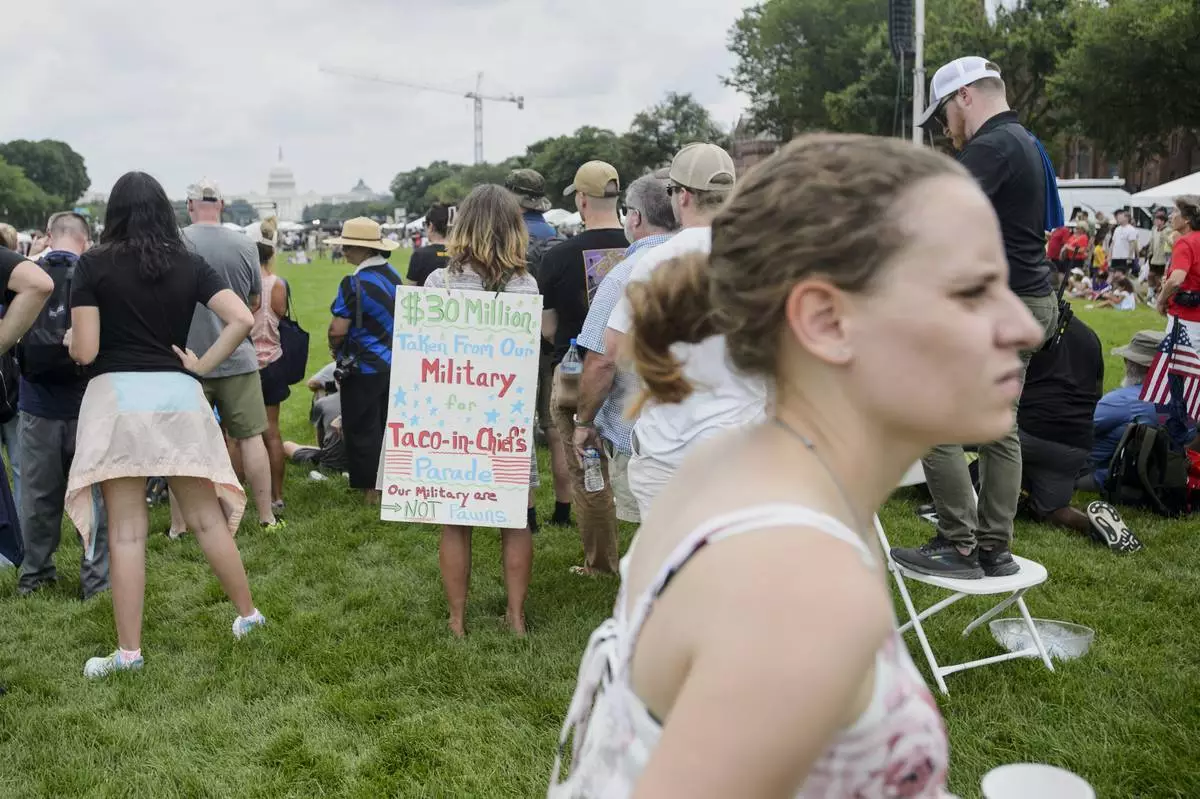 People watch a demonstration by the U.S. Army Drill Team during an event to honor the Army's 250th anniversary, coinciding with President Donald Trump's 79th birthday, Saturday, June 14, 2025, in Washington. (AP Photo/Rod Lamkey, Jr.)
