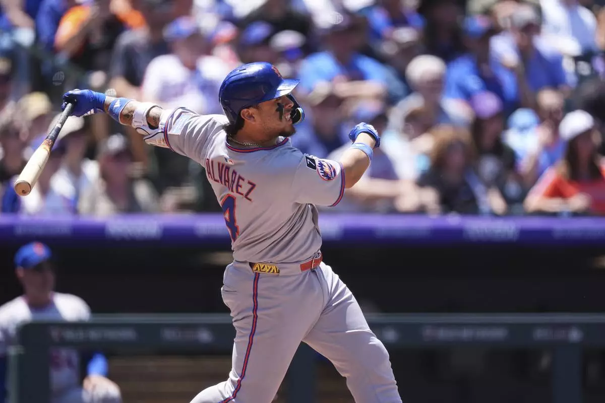 New York Mets' Francisco Alvarez follows the flight of his RBI single off Colorado Rockies starting pitcher Chase Dollander in the second inning of a baseball game, Sunday, June 8, 2025, in Denver. (AP Photo/David Zalubowski)