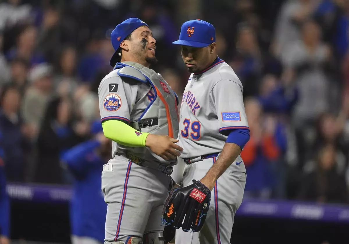 New York Mets catcher Francisco Alvarez, left, congratulates relief pitcher Edwin Díaz after a baseball game against the Colorado Rockies Friday, June 6, 2025, in Denver. (AP Photo/David Zalubowski)