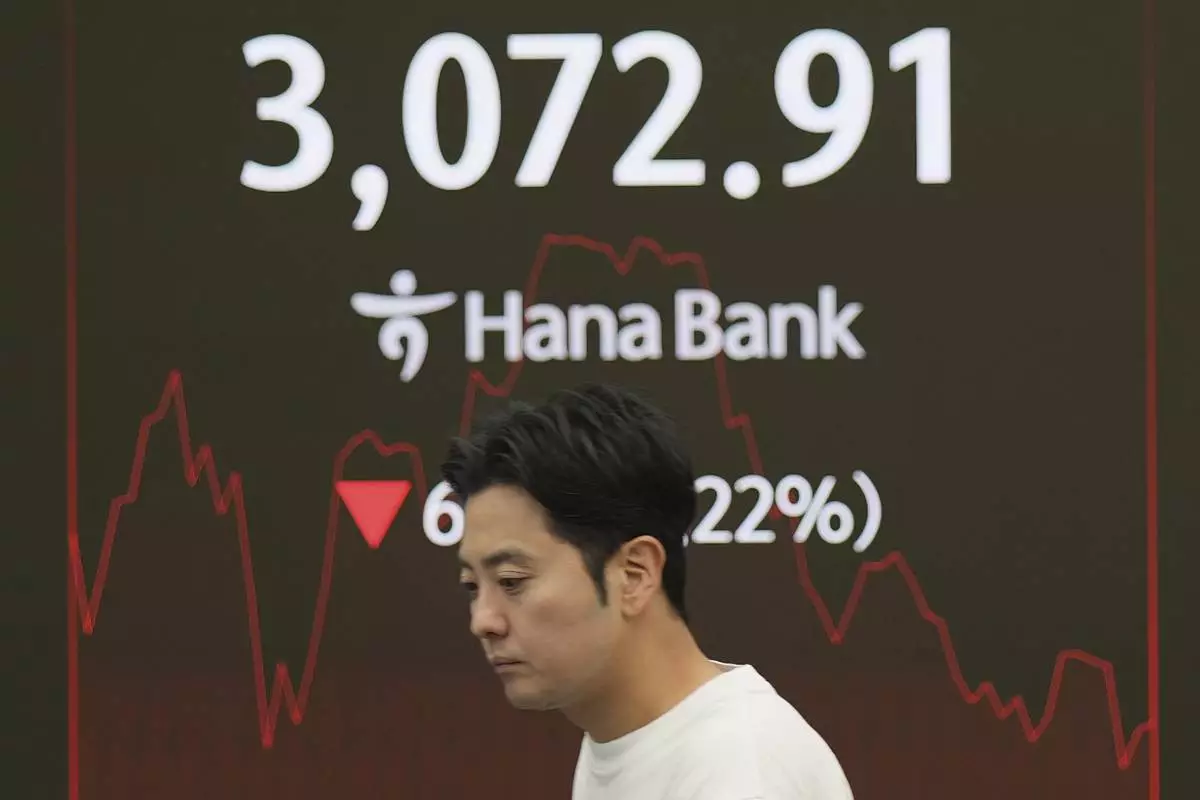 A dealer walks past near screens showing the Korea Composite Stock Price Index (KOSPI) at a dealing room of Hana Bank in Seoul, South Korea, Friday, June 27, 2025. (AP Photo/Lee Jin-man)