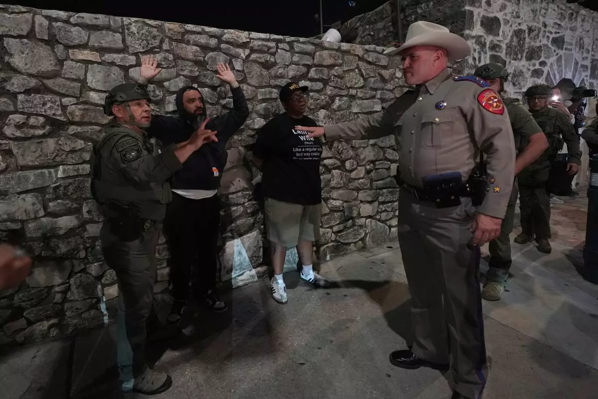 An anti ICE protesters is detained by Texas state troopers near the Alamo in downtown San Antonio, Wednesday, June 11, 2025. (AP Photo/Eric Gay)
