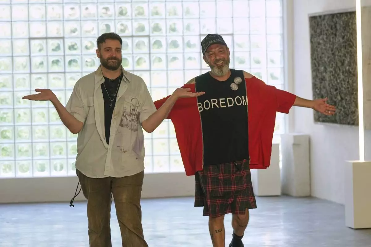 Designers Simone Botte, left, and Filippo Biraghi accept applause after the conclusion of the men's Simon Cracker Spring-Summer 2026 collection, that was presented in Milan, Italy, Sunday, June 22, 2025. (AP Photo/Luca Bruno)