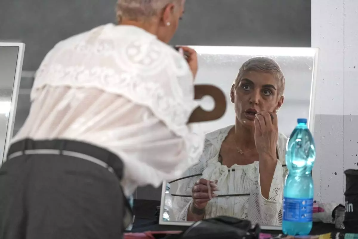 A model adjusts her make up backstage prior to the men's Simon Cracker Spring-Summer 2026 collection, that was presented in Milan, Italy, Sunday, June 22, 2025. (AP Photo/Luca Bruno)