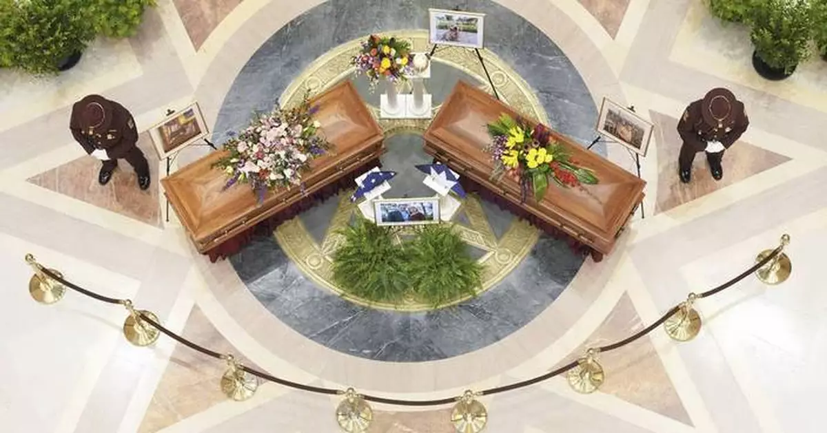 A slain Minnesota lawmaker's beloved dog, Gilbert, stays with her as she and her spouse lie in state