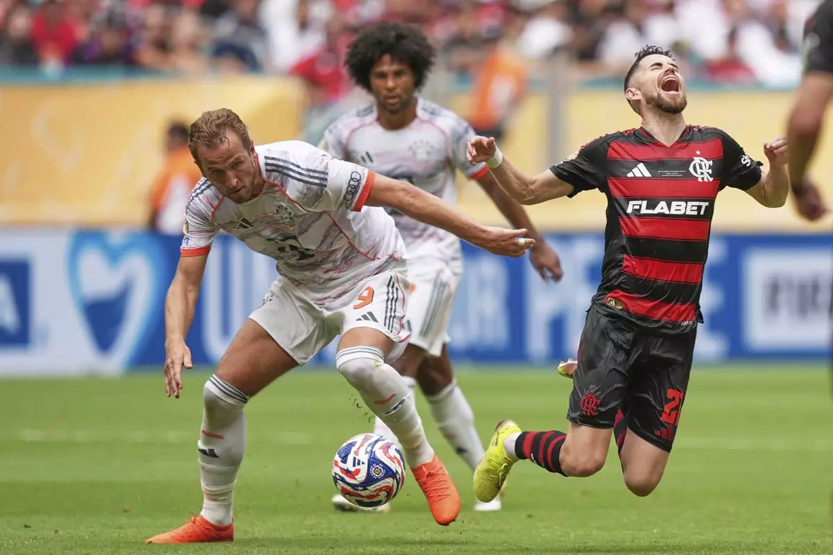 Flamengo's Jorginho, right, falls chased by Bayern Munich's Harry Kane during the Club World Cup round of 16 soccer match between CR Flamengo and Bayern Munich in Miami Gardens, Fla., Sunday, June 29, 2025. (AP Photo/Rebecca Blackwell)