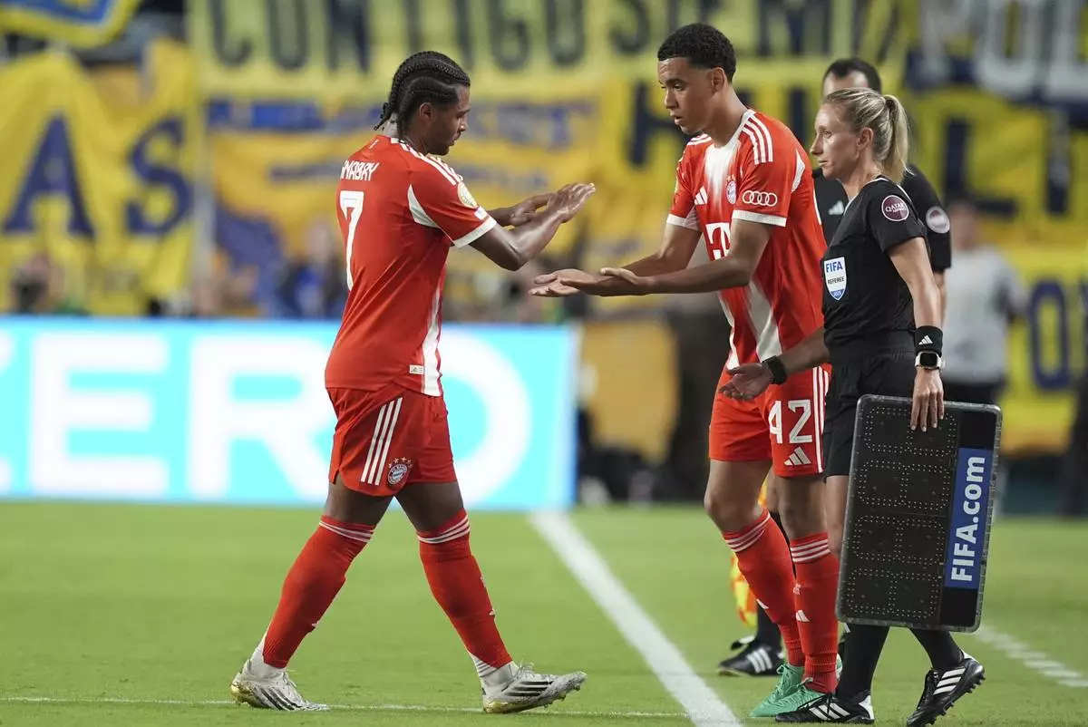 Bayern Munich's Serge Gnabry, left, greets Jamal Musiala after being substituted during the Club World Cup Group C soccer match between Bayern Munich and Boca Juniors in Miami Gardens, Fla., Friday, June 20, 2025. (AP Photo/Rebecca Blackwell)