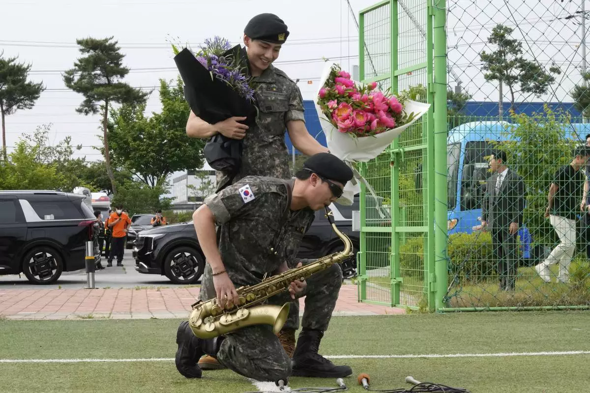 K-pop band BTS members RM, bottom, and V react after being discharged from a mandatory military service in Chuncheon, South Korea, Tuesday, June 10, 2025. (AP Photo/Ahn Young-joon)