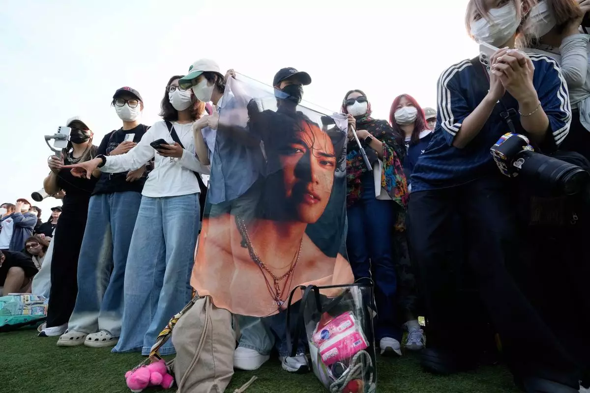 Fans wait for arrival of K-pop band BTS members RM and V before they are discharged from a mandatory military service in Chuncheon, South Korea, Tuesday, June 10, 2025. (AP Photo/Ahn Young-joon)
