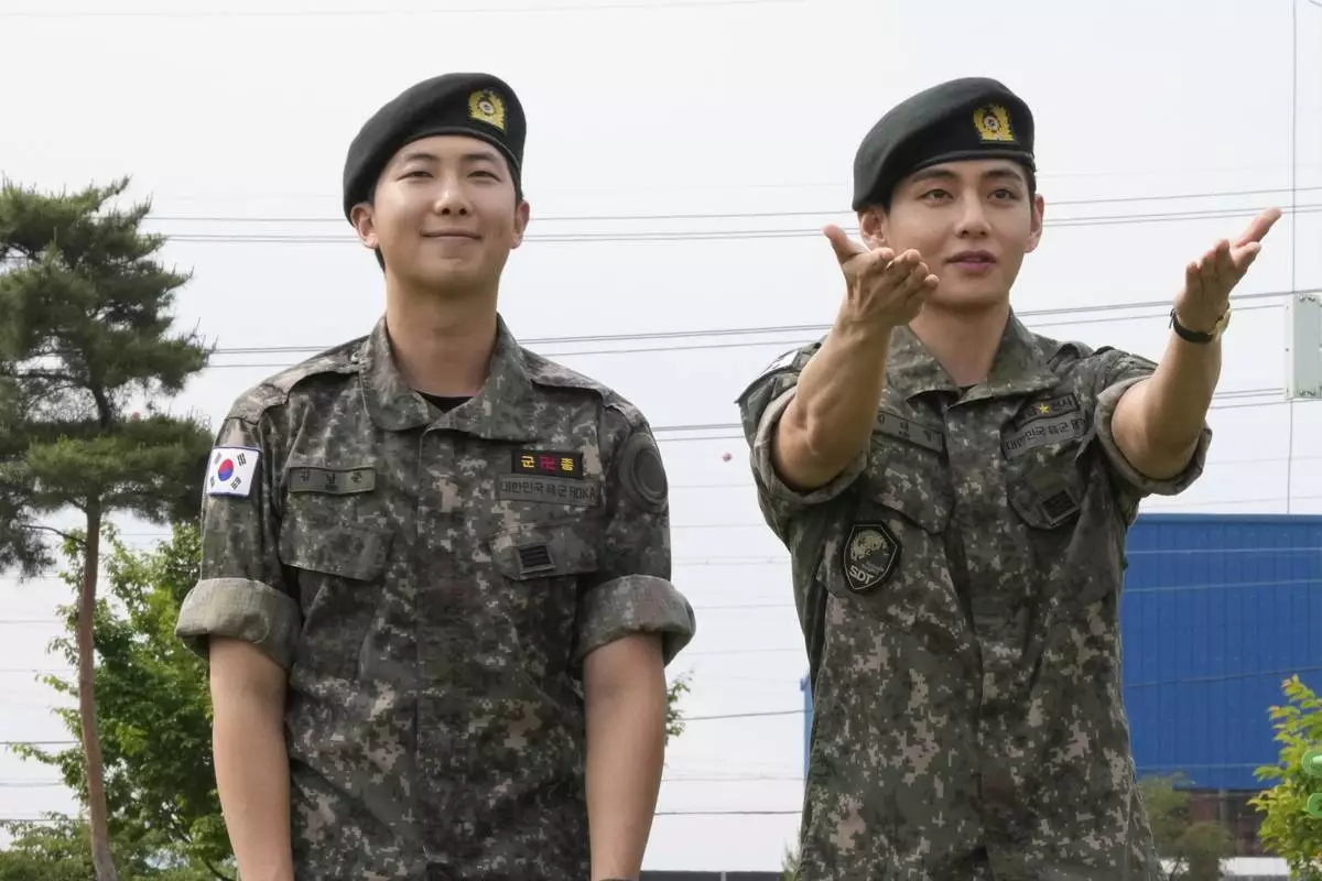 K-pop band BTS members RM, left, and V react after being discharged from a mandatory military service in Chuncheon, South Korea, Tuesday, June 10, 2025. (AP Photo/Ahn Young-joon)