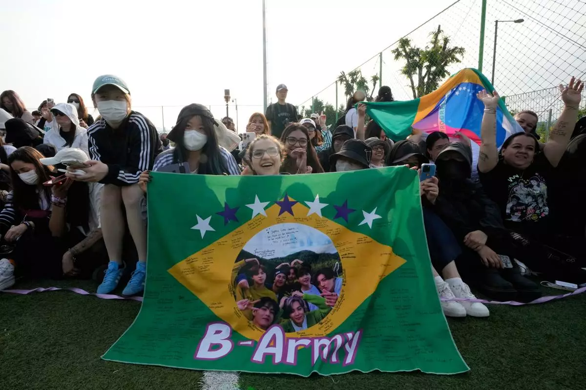 Fans wait for arrival of K-pop band BTS members RM and V before they are discharged from a mandatory military service in Chuncheon, South Korea, Tuesday, June 10, 2025. (AP Photo/Ahn Young-joon)
