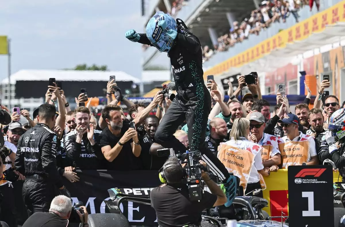 Mercedes driver, Britain's George Russell jumps off his car after winning the F1 Canadian Grand Prix auto race in Montreal, Sunday, June 15, 2025. (Graham Hughes/The Canadian Press via AP)
