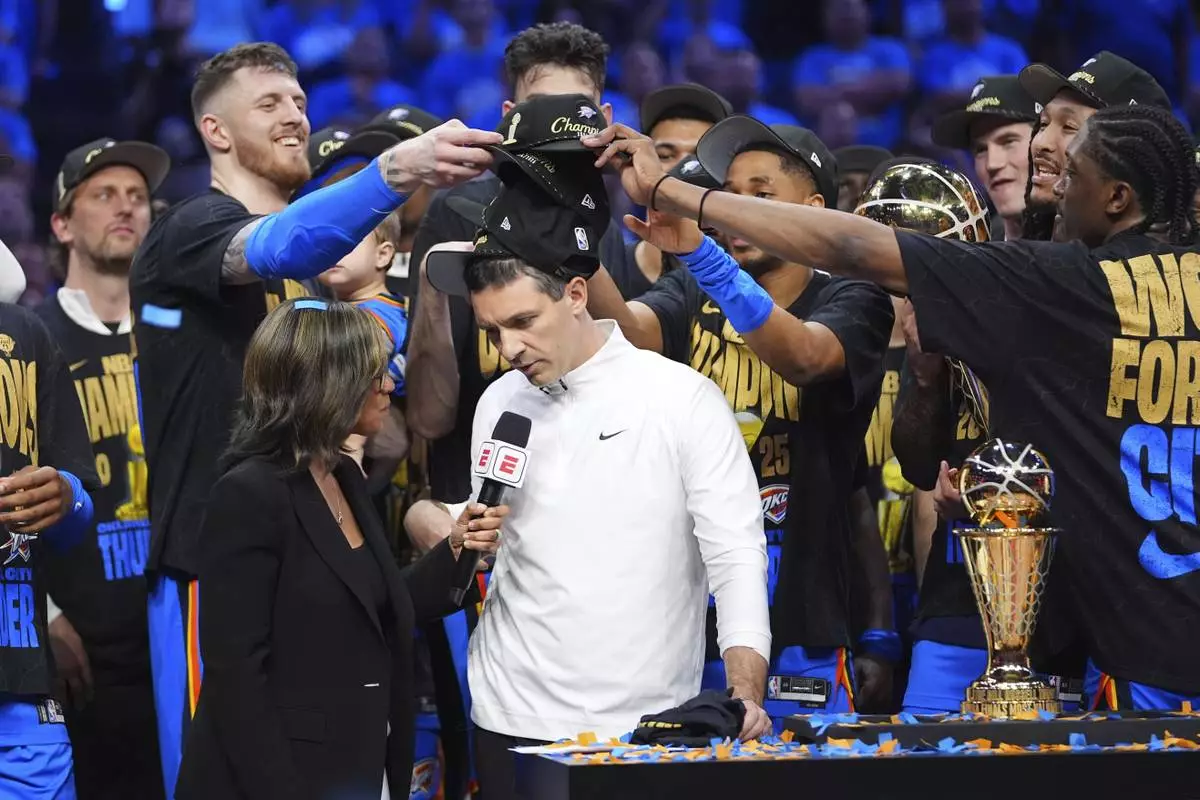 Oklahoma City Thunder players put hats on the head of head coach Mark Daigneault, center, as they celebrate winning the NBA basketball championship with a Game 7 victory against the Indiana Pacers Sunday, June 22, 2025, in Oklahoma City. (AP Photo/Julio Cortez)
