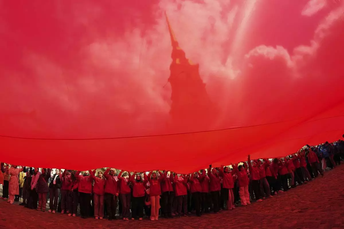 Cadets and young volunteers unfurl a replica of the Soviet Flag of Victory as they mark Victory Day celebrating 80 years after the victory in World War II, The Great Patriotic War for the Soviet Union, next to Saints Peter and Paul Cathedral in St. Petersburg, Russia, May 15, 2025. (AP Photo/Dmitri Lovetsky)