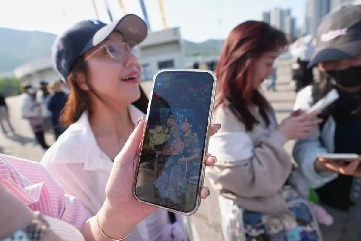 Fans react after she saw K-pop band BTS members Jimin and Jung Kook as they are discharged from a mandatory military service in Yeoncheon, South Korea, Wednesday, June 11, 2025. (AP Photo/Lee Jin-man)