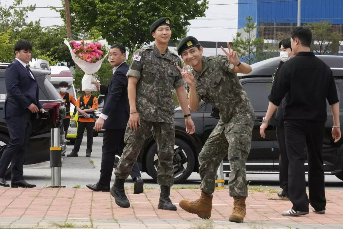 K-pop band BTS members RM, center left, and V, center right, react after being discharged from a mandatory military service in Chuncheon, South Korea, Tuesday, June 10, 2025. (AP Photo/Ahn Young-joon)