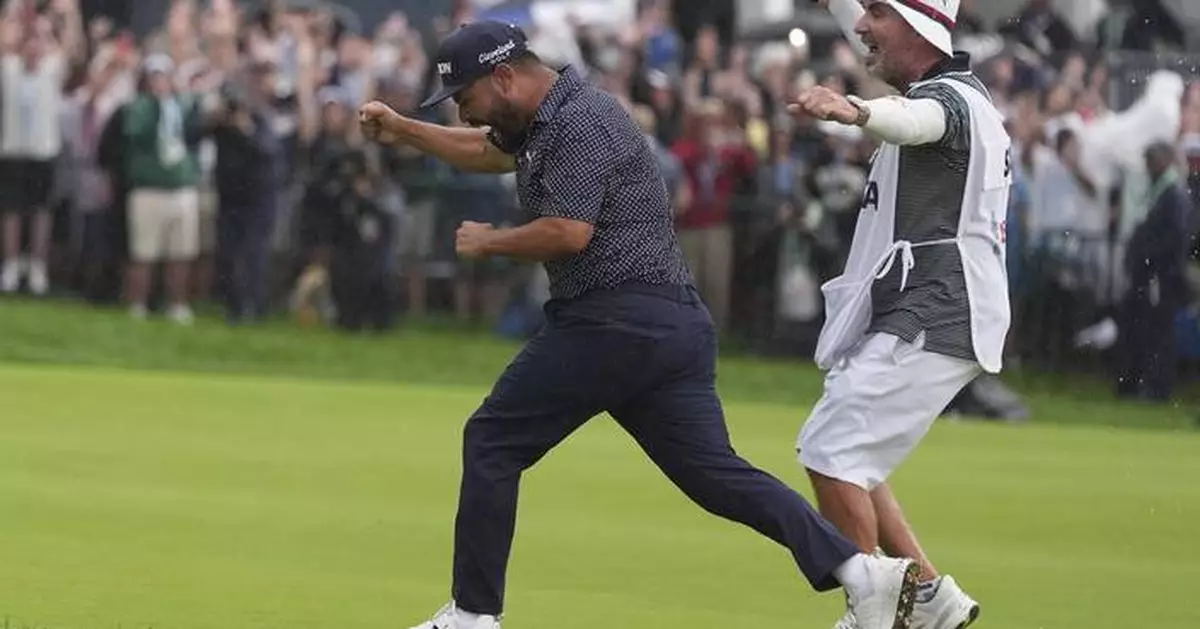 A caddie at heart, Bones Mackay makes sure to get the 18th flag to Spaun's bagman