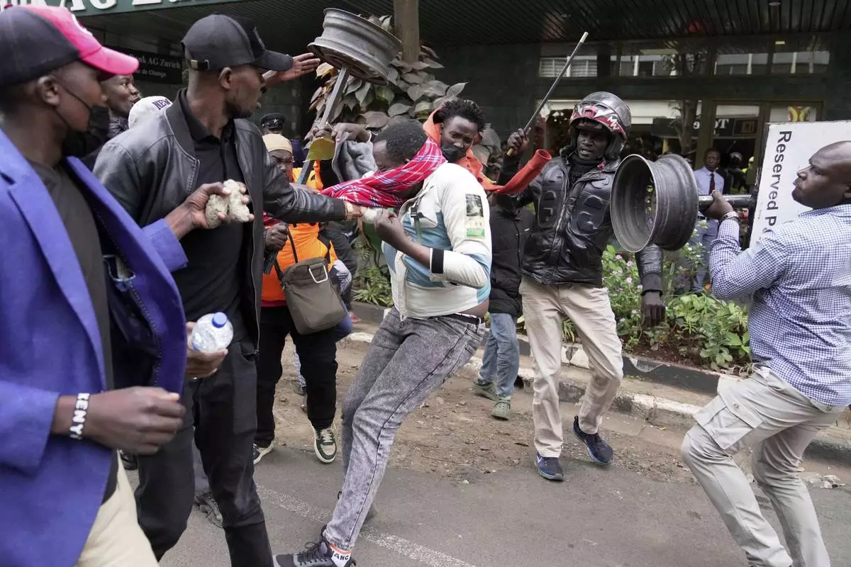 CORRECTS ACTION TO ATTACKED - A suspected pro government supporter is attacked by protesters during a demonstration over the death of blogger Albert Ojwang in police custody, in downtown Nairobi, Kenya, Tuesday, June 17, 2025. (AP Photo/Brian Inganga)