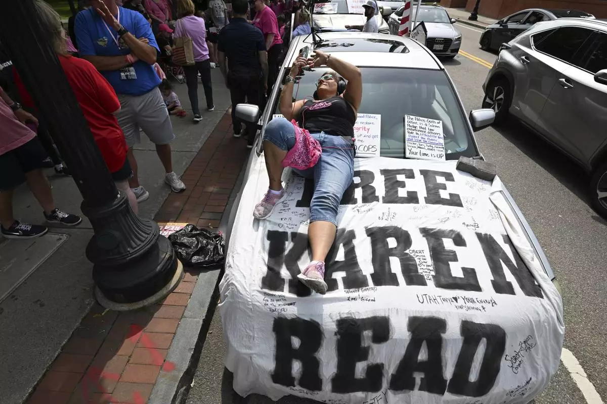 Dina Warchal, of Waltham, MA, a Karen Read supporter, listens to closing arguments of Read's trial from her car parked at the edge of the protest buffer zone around Norfolk Superior Court, Friday, June 13, 2025, in Dedham, Mass. (AP Photo/Josh Reynolds)