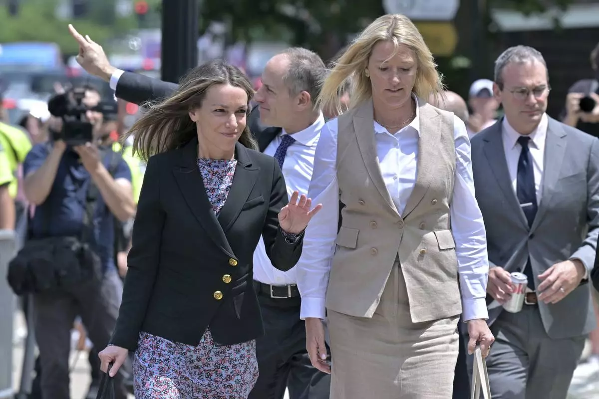Karen Read, left, and her lawyer David Yanetti, second from left, acknowledge supporters as they return to the Dedham, Mass. courthouse, where the judge was to issue instructions to the jury in Read's trial at Norfolk Superior Court, Friday, June 13, 2025, in Dedham, Mass. (AP Photo/Josh Reynolds)