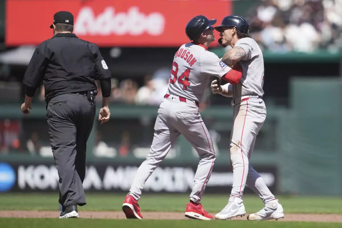 Boston Red Sox' Jarren Duran, right, is held back by third base coach Kyle Hudson (84) while arguing with umpire Doug Eddings, left, during the eighth inning of a baseball game against the San Francisco Giants in San Francisco, Sunday, June 22, 2025. (AP Photo/Jeff Chiu)