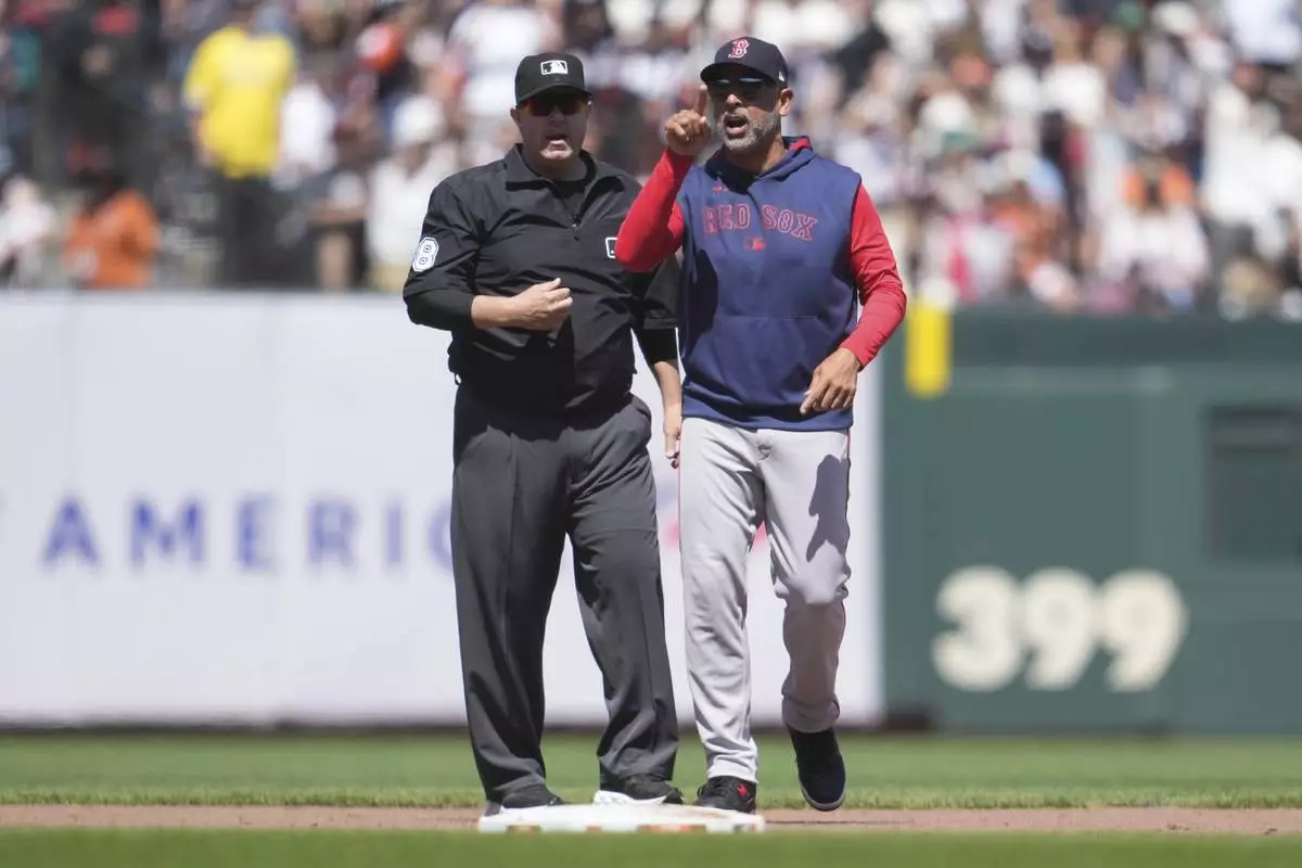 Boston Red Sox manager Alex Cora, right, gestures after being ejected by umpire Doug Eddings, left, during the eighth inning of a baseball game against the San Francisco Giants in San Francisco, Sunday, June 22, 2025. (AP Photo/Jeff Chiu)