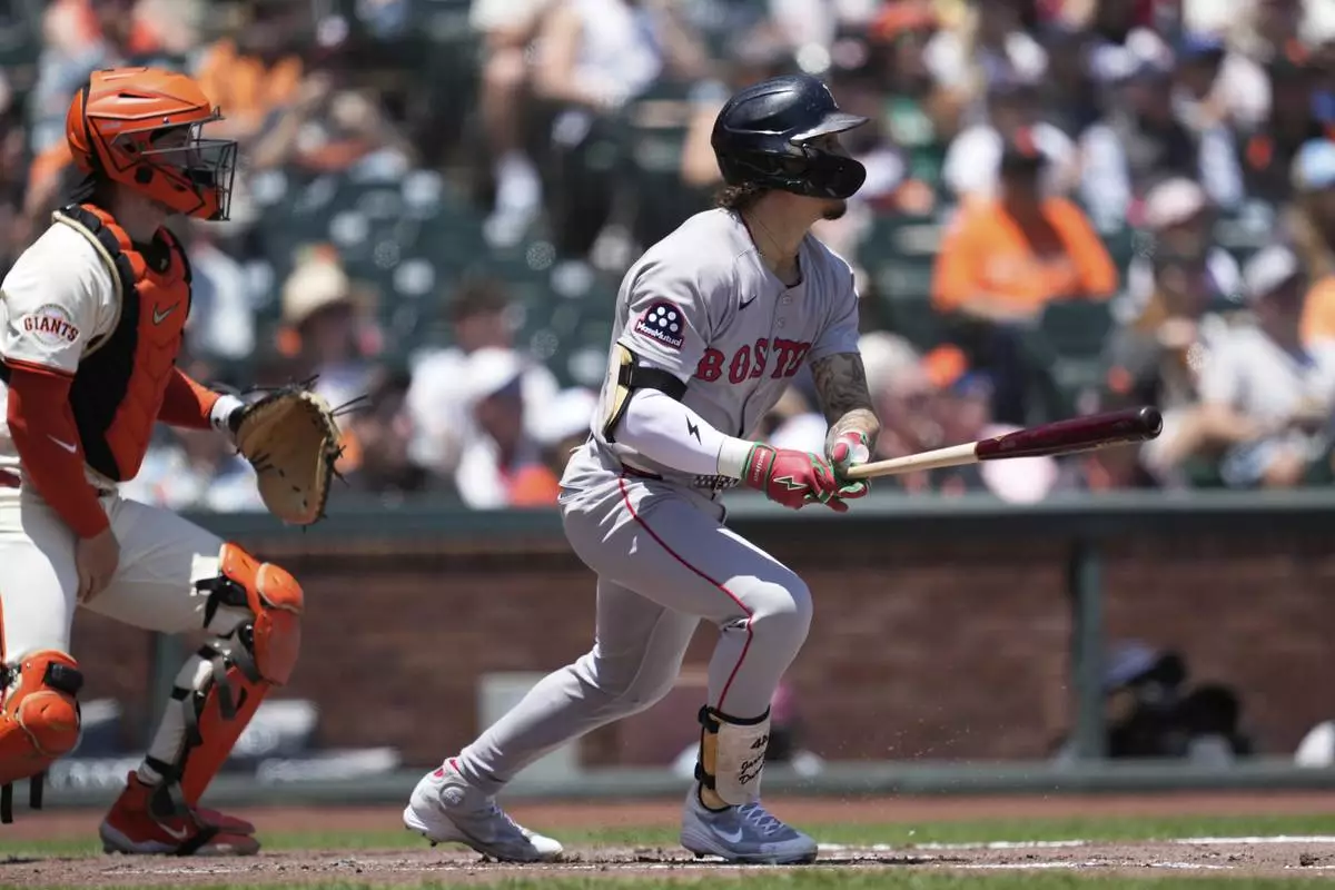 Boston Red Sox's Jarren Duran, right, watches his fly ball that San Francisco Giants left fielder Heliot Ramos made an error on that allowed Roman Anthony to score next to catcher Patrick Bailey, left, during the first inning of a baseball game in San Francisco, Sunday, June 22, 2025. (AP Photo/Jeff Chiu)