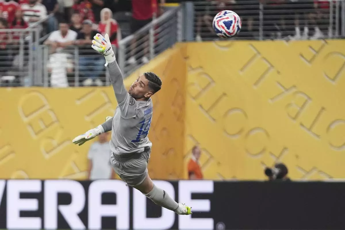 Porto's goalkeeper Claudio Ramos is airborne as he fails to stop a goal from Al Ahly's Mohamed Ali Ben Romdhane during the Club World Cup Group A soccer match between FC Porto and Al Ahly in East Rutherford, N.J., Monday, June 23, 2025. (AP Photo/Frank Franklin II)