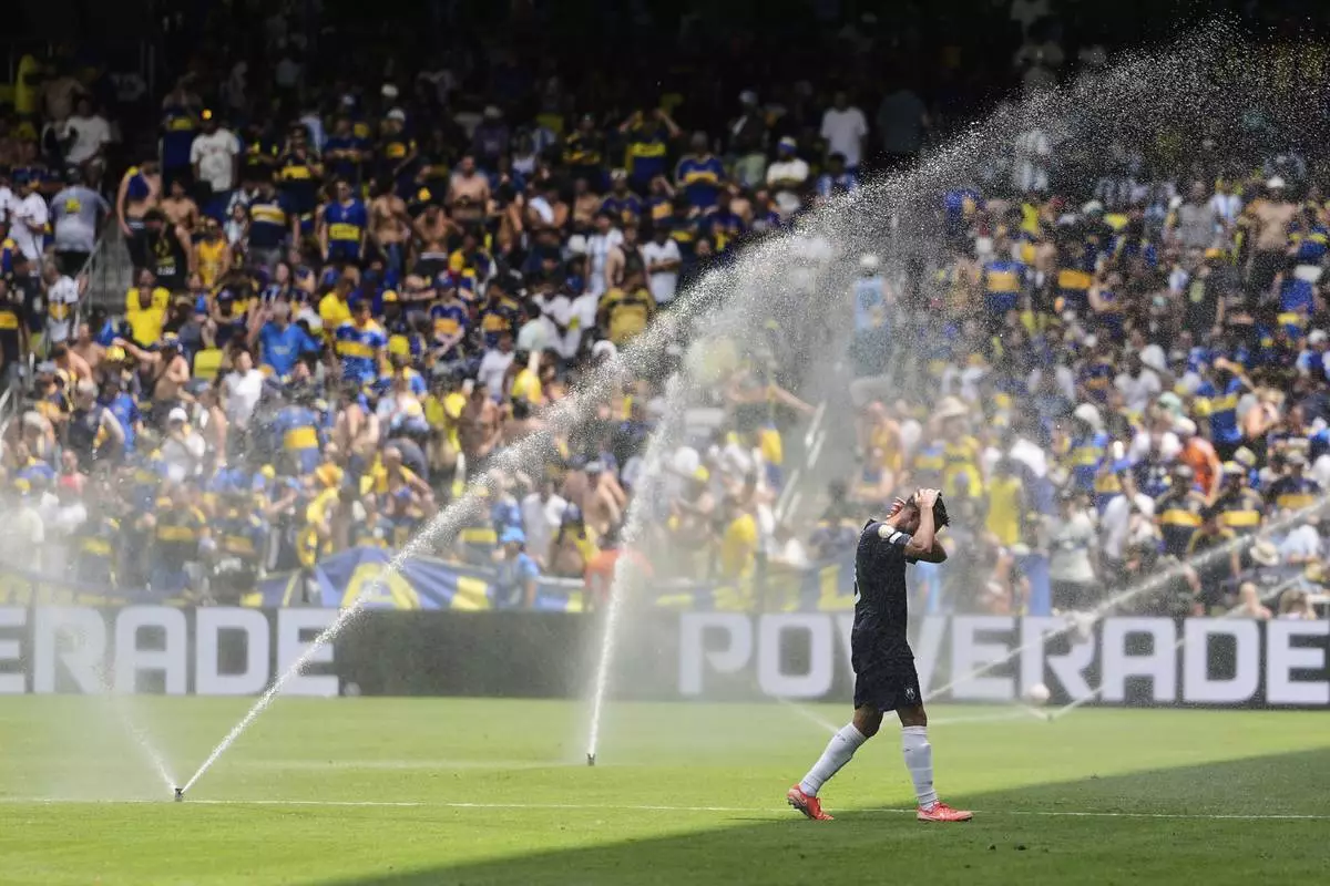 Auckland City's Gerard Garriga cools off under the sprinklers during a water break in the Club World Cup Group C soccer match between Auckland City and Boca Juniors in Nashville, Tenn., Tuesday, June 24, 2025. (AP Photo/George Walker IV)