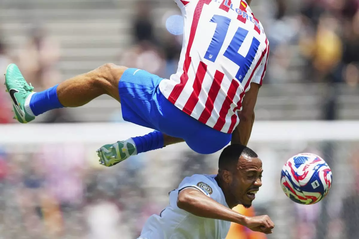 Botafogo's Marlon Freitas, bottom, heads a ball under Atletico Madrid's Marcos Llorente during the Club World Cup Group B soccer match between Atletico Madrid and Botafogo in Pasadena, Calif., Monday, June 23, 2025. (AP Photo/Jae Hong)