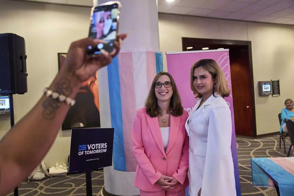 Bella Bautista, 22, right, a trans woman, has a photo taken with Rep. Sarah McBride, D-Del., the first trans woman to be a member of Congress, during a reception held by the Christopher Project, a trans rights organization, after the Human Rights Conference during World Pride, Thursday, June 5, 2025, in Washington. (AP Photo/Jacquelyn Martin)