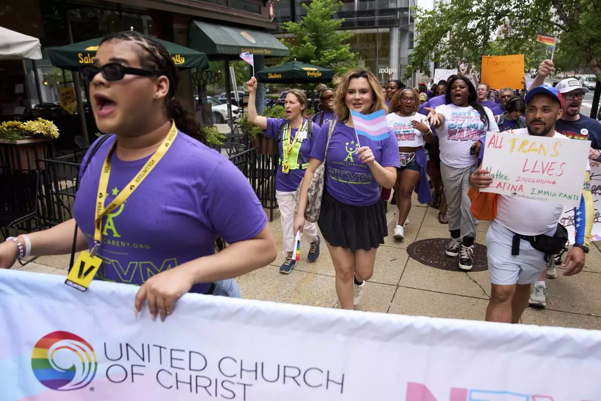Bella Bautista, 22, center, a trans woman, attends the National Trans Visibility March, en route to join the World Pride Rally on the National Mall, Sunday, June 8, 2025, in Washington. (AP Photo/Jacquelyn Martin)