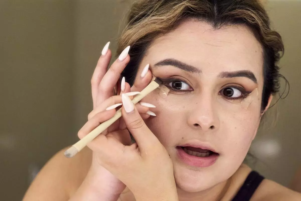 Bella Bautista, 22, a trans woman, does her makeup in her hotel room in Arlington, Va., Wednesday, June 4, 2025, ahead of attending a dinner for strategic organizers of the National Trans Visibility March, during World Pride. (AP Photo/Jacquelyn Martin)