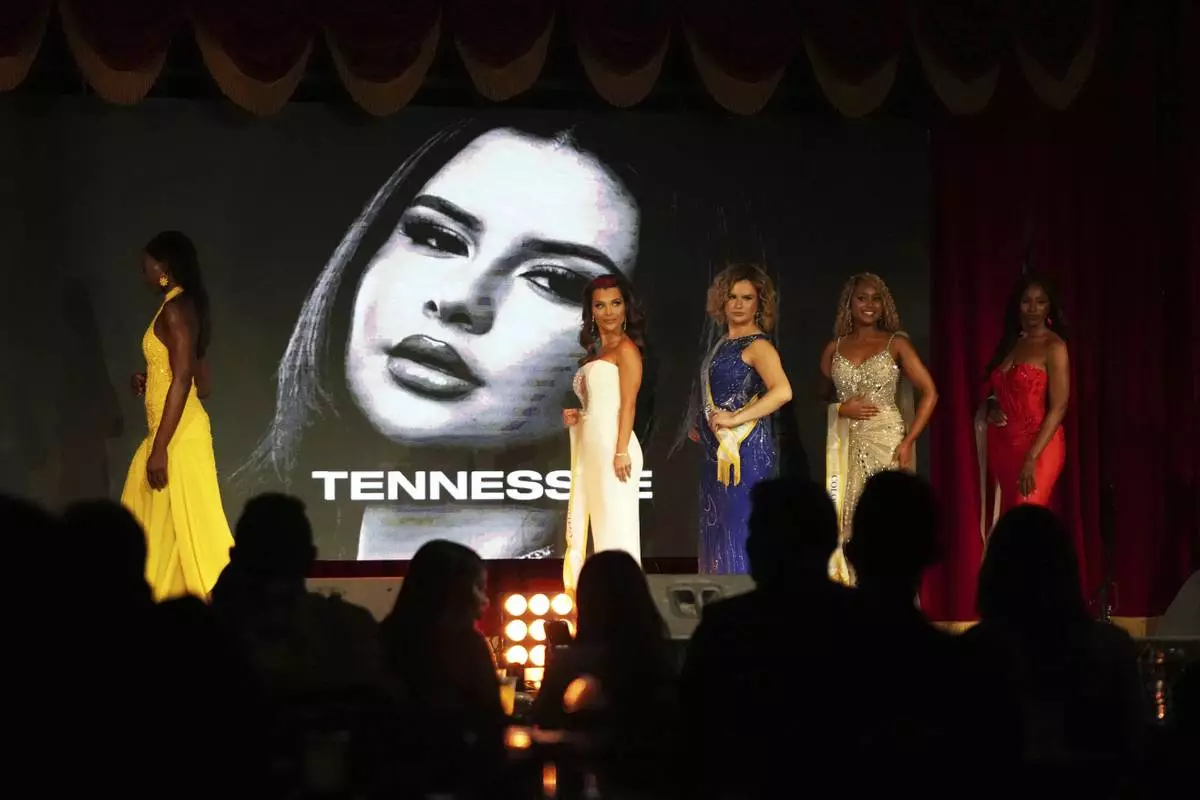 Bella Bautista, 22, third from left, a trans woman, walks on the stage with fellow contestants as her portrait is displayed during the Miss Supranational USA pageant, Saturday, May 17, 2025, in Miami. Bautista says she is the first trans woman to compete in this pageant. (AP Photo/Lynne Sladky)