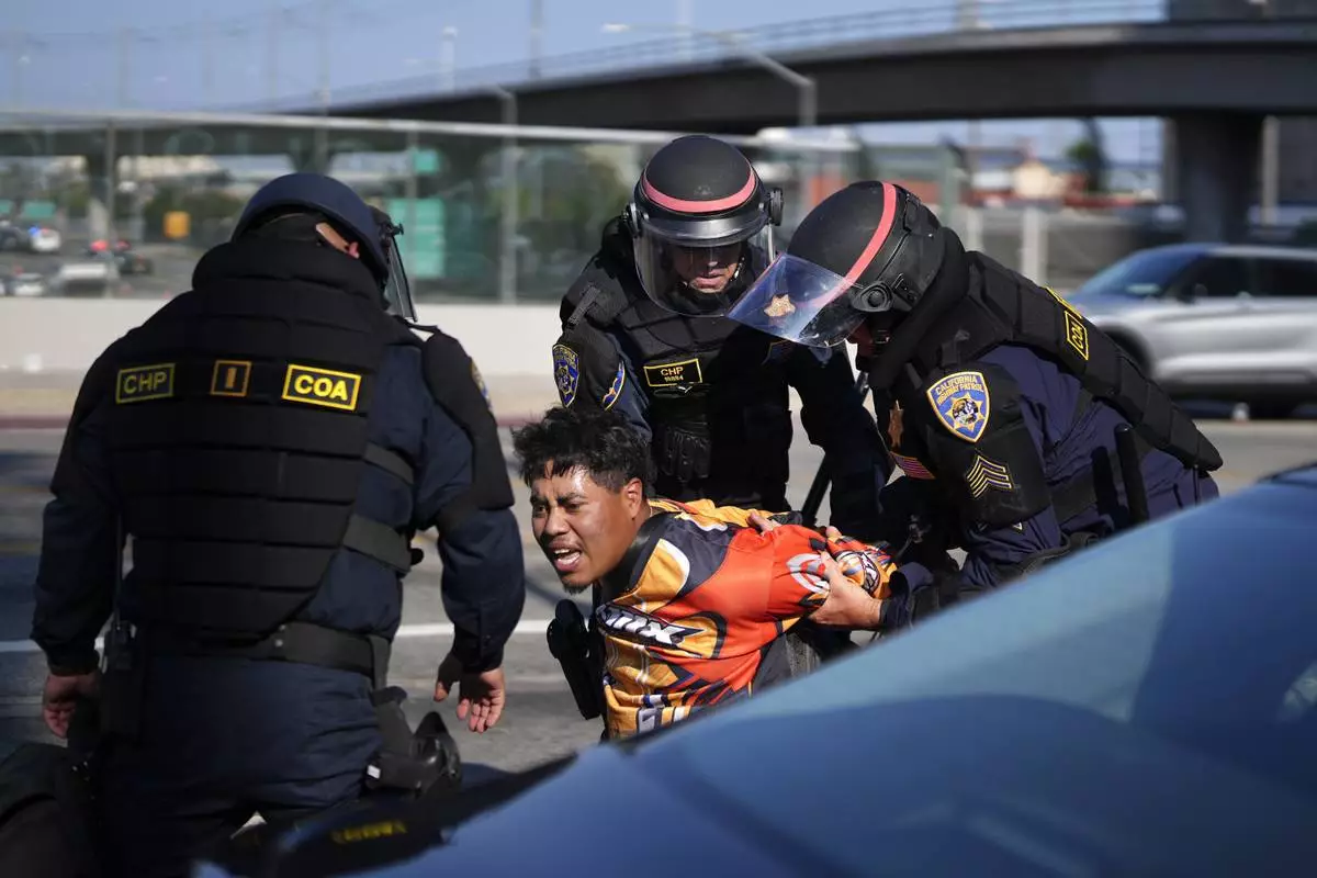 A protester is arrested by California Highway Patrol near the federal building in downtown Los Angeles on Tuesday, June 10, 2025. (AP Photo/Eric Thayer)