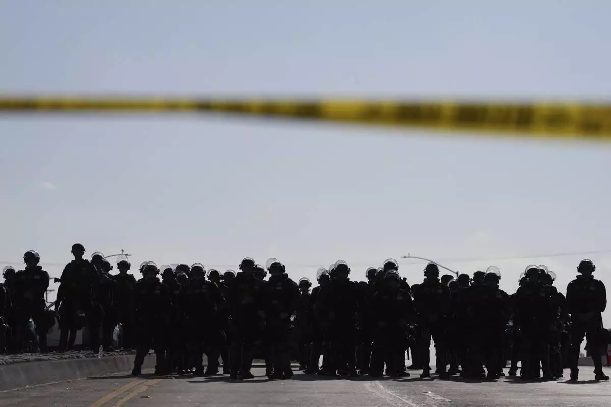 Law enforcement officers block a road during a protest on Wednesday, June 11, 2025, in Paramount, Calif. (AP Photo/Jae C. Hong)