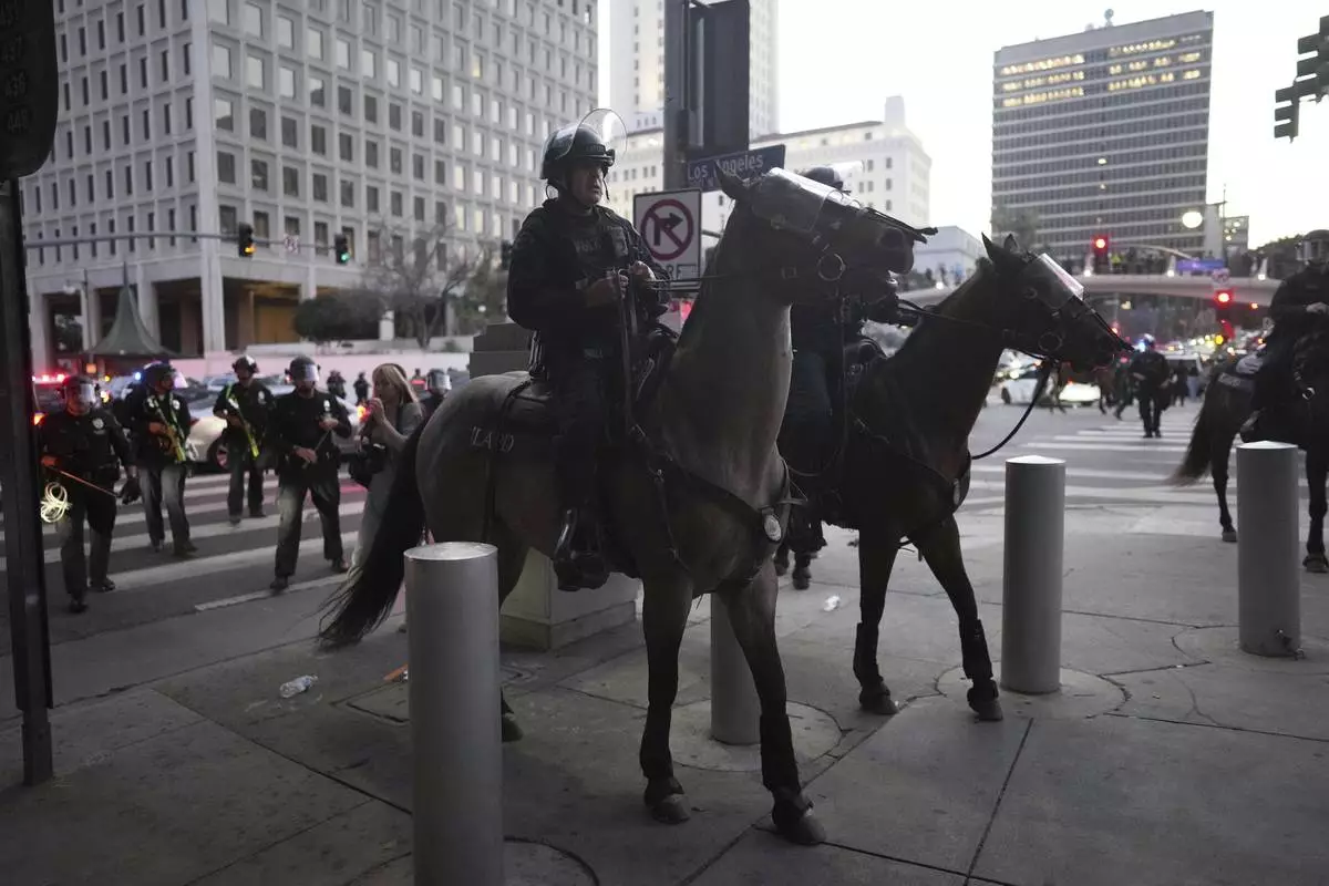 Los Angeles Police Department officers on horseback move through a street during a protest on Tuesday, June 10, 2025, in Los Angeles. (AP Photo/Eric Thayer)