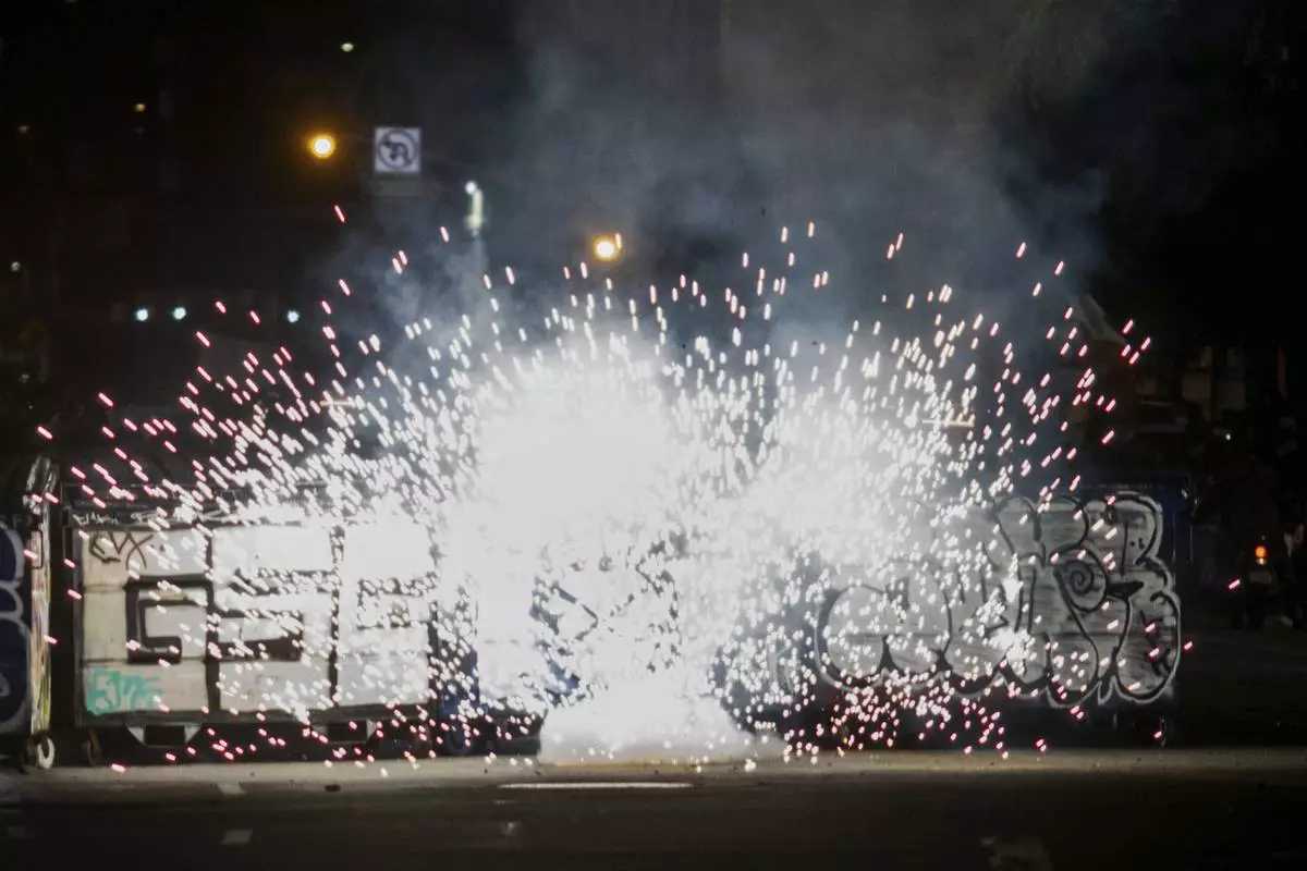 Fireworks explode during protests over the Trump administration's immigration raids in Los Angeles, Monday, June 9, 2025. (AP Photo/Ethan Swope)