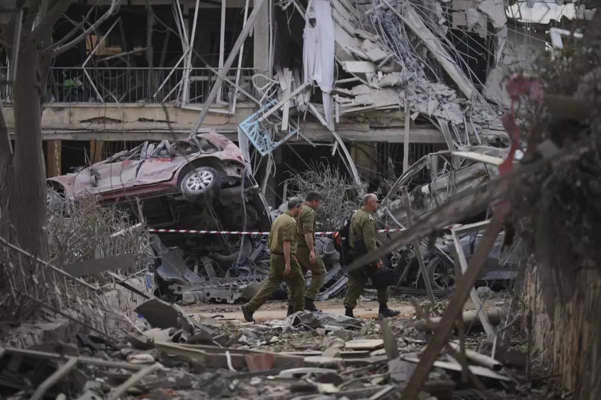 Israeli security forces inspect destroyed residential buildings that were hit by a missile fired from Iran, in Ramat Gan, near Tel Aviv, Israel, on Saturday, June 14, 2025. (AP Photo/Ariel Schalit)