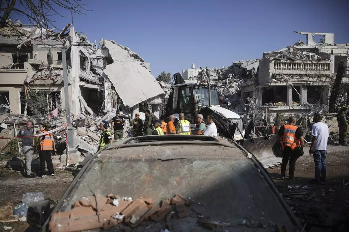 Israeli security forces inspect the site of homes destroyed by a missile fired from Iran, in Rishon Lezion, Israel, on Saturday, June 14, 2025. (AP Photo/Ohad Zwigenberg)