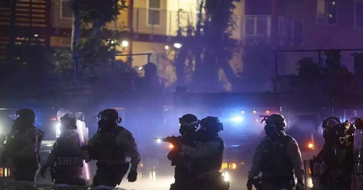 After tear gas and street fires, a Los Angeles community cleans up as National Guard troops arrive