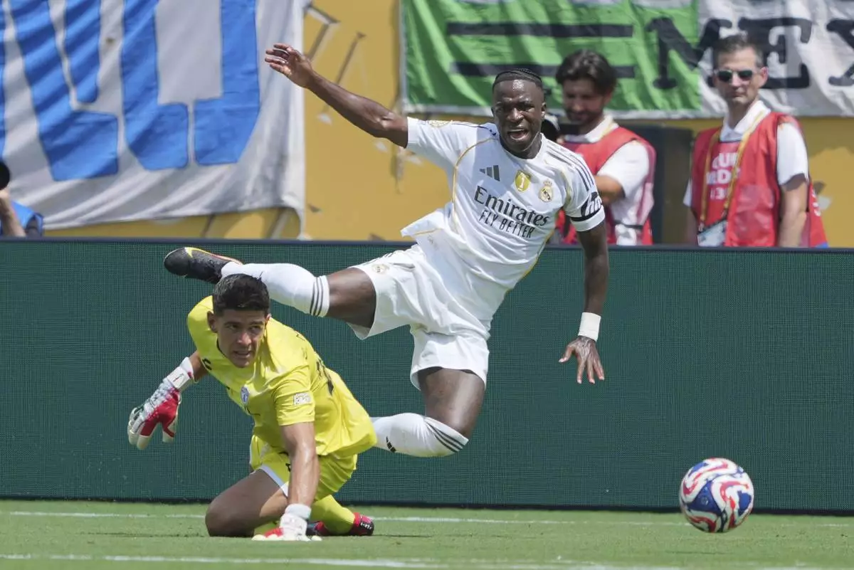 Pachuca's Carlos Moreno, bottom, and Real Madrid's Vinicius Junior battle for the ball during the Club World Cup Group H soccer match between Real Madrid and CF Pachuca in Charlotte, N.C., Sunday, June 22, 2025. (AP Photo/Chris Carlson)