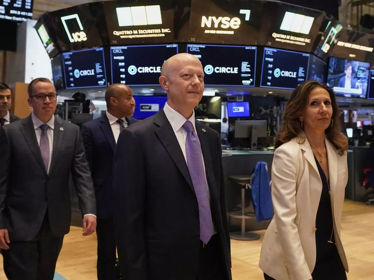 Jeremy Allaire, center, Co-Founder, Chairman &amp; CEO of Circle, escorted by NYSE President Lynn Martin, right, on the floor of the New York Stock Exchange, Thursday, June 5, 2025. (AP Photo/Richard Drew)